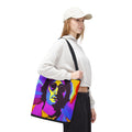 Person holding a colorful tote bag with a graphic design on a white background