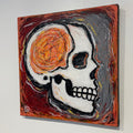 Abstract painting of a skull with orange and black elements on a gray background